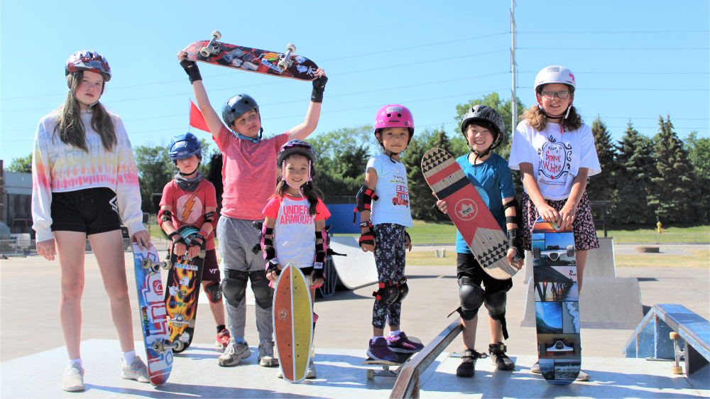 Young kids posing with their skateboards