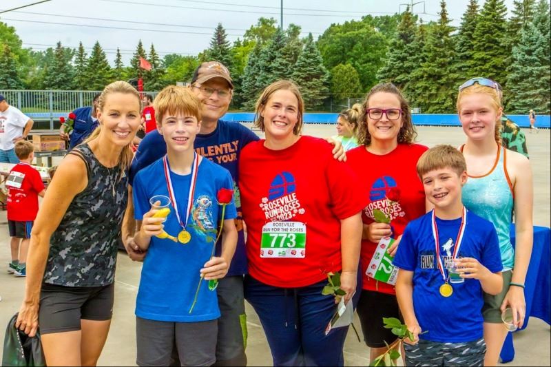 Family smiling for photo after run for the roses race